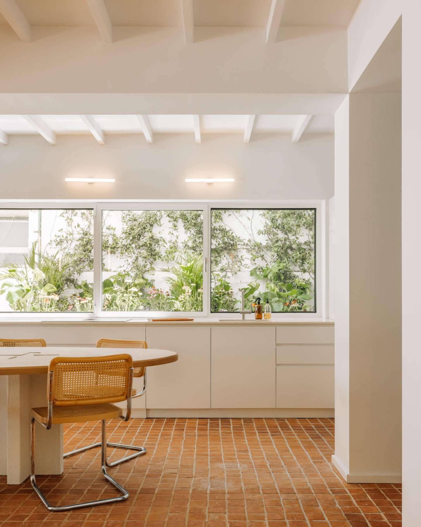 cucina a vista cucina bianca tavolo sedie in tubolare e paglia di vienna